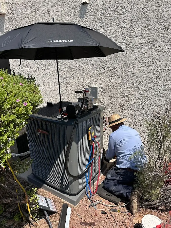 HVAC technician performing outdoor AC maintenance in Manchester